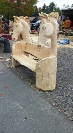 two wooden horses sitting on top of a bench made out of wood planks and plywood