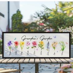 there is a sign that says grandpa's garden with flowers in the center and butterflies on it