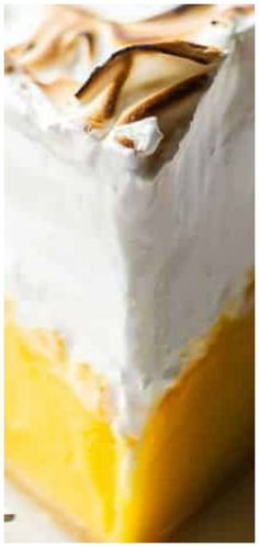 there is a piece of cake with white frosting and yellow icing on it