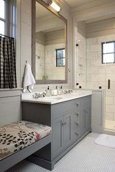 a bathroom with a sink, mirror and shower in it's center area next to a bench