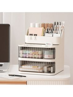 an office desk with a computer and various crafting supplies on it's shelf