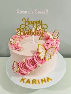 a birthday cake decorated with pink flowers and gold butterflies is sitting on a white plate