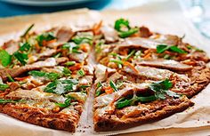 a pizza sitting on top of a piece of paper next to a glass of water