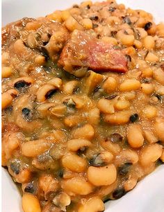 a white plate topped with beans and meat