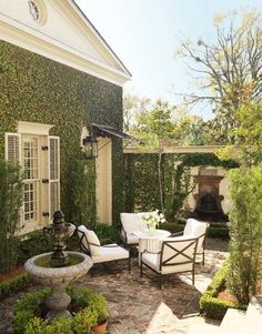 an outdoor living room with white furniture and greenery on the walls is featured in this instagram