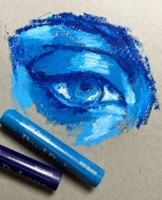 two blue crayons next to each other with an eye drawn on it in the middle