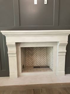 an empty fireplace in a room with gray walls