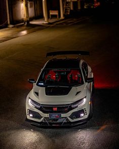 a white car parked on the street at night