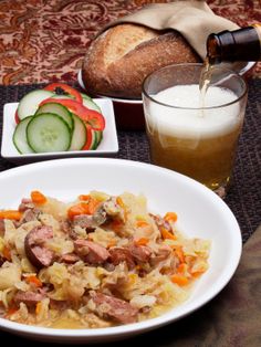 a bowl of food and a glass of beer on a table