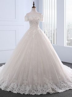 a wedding dress on display in front of a window