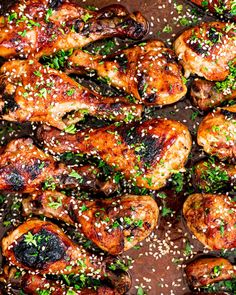 chicken with sesame seeds and garnishes on a baking sheet, ready to be cooked