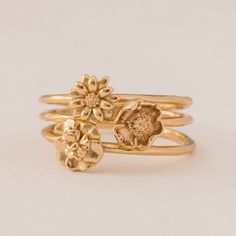 three gold rings with flowers on them