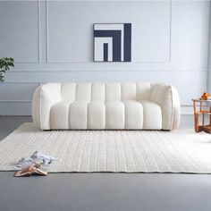 a white couch sitting on top of a rug in a living room