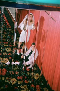 a bride and groom are reflected in a mirror on the floor next to each other