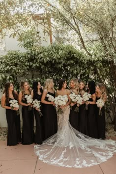 a bride and her bridal party in black dresses