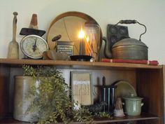 a shelf with various items on top of it and a lit candle in the middle