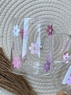 two glass mugs sitting on top of a rug next to a brown and white straw