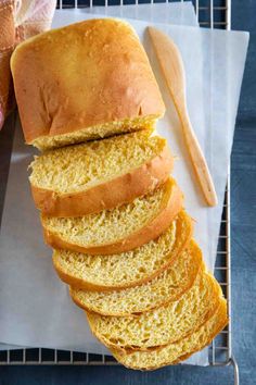 a loaf of bread sitting on top of a cutting board next to some sliced bread