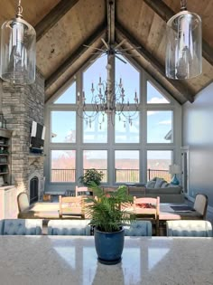 a dining room table with chairs and a chandelier hanging from it's ceiling