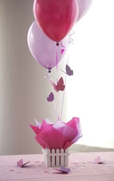 some pink and purple balloons are in a vase