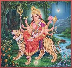 the hindu goddess sitting on top of a tiger in front of a river and trees