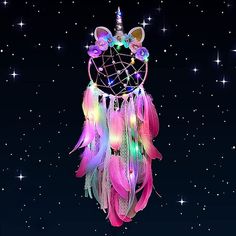 a pink and blue dream catcher with lights on it next to a notepad that says happy new year