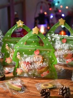 three bags with christmas decorations on them sitting on a table next to some pine cones