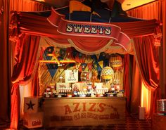 an image of a sweet shop display in the middle of the room with red drapes