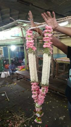 a man is holding flowers in front of his face and hands as he holds it up