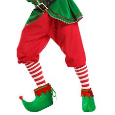 a man dressed up as a christmas elf holding a candy cane in one hand and pointing to the side