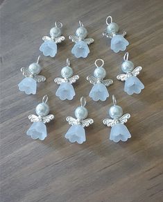 twelve glass angel charms sitting on top of a wooden table