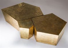 two gold colored tables sitting on top of each other