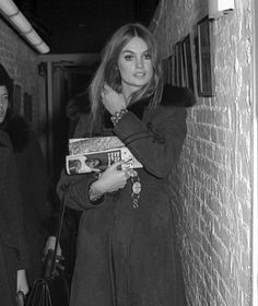 black and white photograph of two women walking down an alleyway holding books in their hands