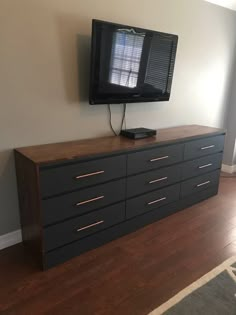 a flat screen tv sitting on top of a dresser next to a wall mounted television