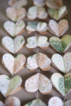 paper hearts are arranged in the shape of flowers and leaves on a table with string