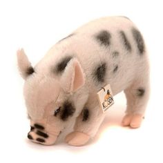 a small stuffed animal pig with black and white spots on it's face, standing upright