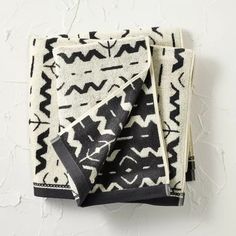 two black and white towels folded on top of each other, one with an abstract design