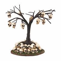 a group of skulls sitting on top of a base under a tree with no leaves