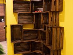 a shelf made out of wooden crates in a room with yellow walls and wood flooring