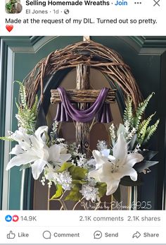 a cross with flowers and greenery in front of it on a tweel