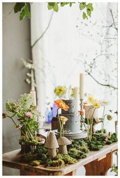 the table is covered with moss and flowers