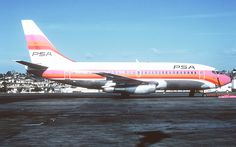 a large passenger jet sitting on top of an airport tarmac with buildings in the background