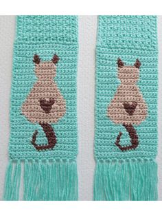 two crocheted scarfs with animals on them, one is blue and the other is green