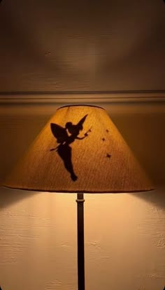 a lamp with a shadow of a fairy on it