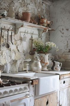 an old fashioned kitchen with pots and pans on the wall, stove and oven