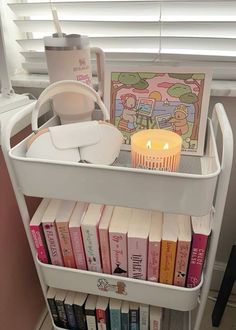 a book shelf with books and a lit candle