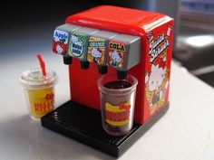 a toy coffee machine with two cups next to it