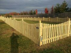 a wooden fence in the middle of a grassy field