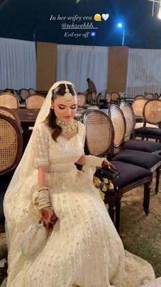 a woman sitting on top of a chair wearing a wedding dress