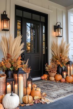 a front porch decorated for fall with pumpkins and candles